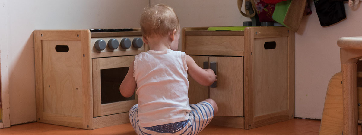 toddler sat in front of cupboards